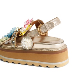 Kurt Geiger London gold platform sandal with multicolour floral embellishments, ankle buckle strap, and chunky striped flatform sole.