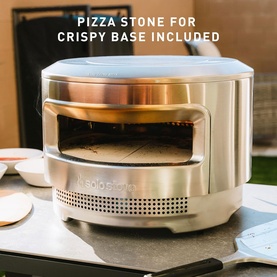 Stainless steel outdoor pizza oven with copper interior dome and pizza stone for crispy base, shown on outdoor countertop