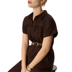 Model wearing Whistles brown short-sleeve shirt dress with ruched bodice, styled with a tan belt and gold bangles.