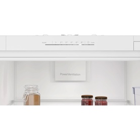 Neff integrated fridge interior showing white shelving, PowerVentilation panel, and storage jars with food items visible
