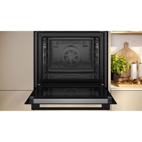 Neff built-in single oven in black, shown open with interior cavity visible, integrated into a kitchen setting