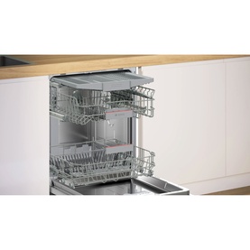 Neff fully integrated dishwasher with open door revealing two pull-out wire basket racks, built into white kitchen cabinetry