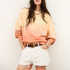 Model wearing Bash yellow ombr&eacute; sweatshirt with white denim shorts and brown leather belt with gold buckle