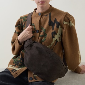 Model carrying InWear Rasida Suede Belt Bag in Chocolate Brown, curved silhouette with wide shoulder strap, styled with patterned wool jacket
