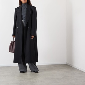 Model wearing Rohe Double-Breasted Tailored Coat in black wool, styled with grey wide-leg trousers, turtleneck, and burgundy handbag.