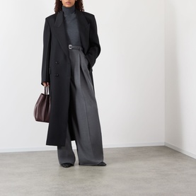 Model wearing Rohe Double-Breasted Tailored Coat in black wool, styled with grey wide-leg trousers and carrying a burgundy leather tote.