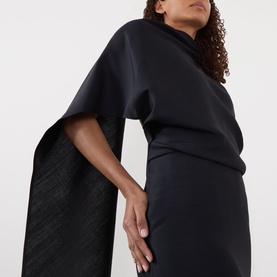 Model wearing Rohe Cape Pencil Dress in Night, featuring asymmetric cape sleeves, round neckline and midi-length silhouette in silk blend.