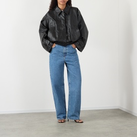 Model wearing Rohe Bruun Straight-Leg Jeans in Heritage Blue, low-rise straight fit, paired with a black leather jacket and strappy sandals.