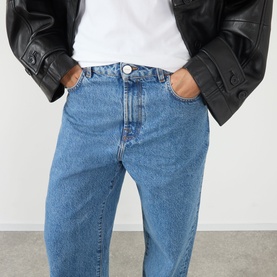 Model wearing Rohe Bruun Straight-Leg Jeans in Heritage Blue, low-rise straight-leg cut with tobacco stitching, styled with white tee and black
