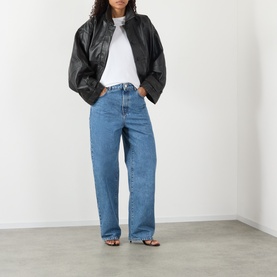 Model wearing Rohe Bruun Straight-Leg Jeans in Heritage Blue, low-rise straight-leg fit, styled with black leather jacket and white tee.