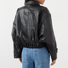Model wearing Rohe black leather jacket, back view, elasticated hem, worn with blue jeans