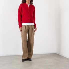 Model wearing Rohe Classic Knit Cardigan in red with round neck and button fastening, styled with tan wide-leg trousers and black loafers.