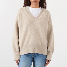 Model wearing Rohe Classic Moulin&eacute; Sweater in Oat Melange, V-neckline, dropped shoulders, styled with white tee and blue jeans.