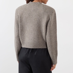 Model wearing Rohe Statement Moulin&eacute; Cardigan in Dark Taupe Melange, back view, cropped silhouette with dropped shoulders, styled with black trousers.