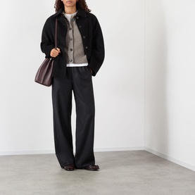 Model wearing Rohe Statement Moulin&eacute; Cardigan in Dark Taupe Melange, styled with black jacket, wide-leg trousers, and burgundy shoulder bag.