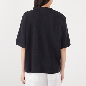 Model wearing Rohe Merino Wool T-Shirt in Anthracite Melange, back view, oversized fit, styled with white trousers