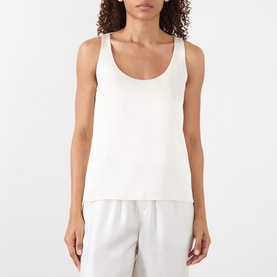 Model wearing Rohe Solid Fluid Top in ivory, scoop neckline, sleeveless satin finish, styled with white wide-leg trousers.