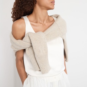 Model wearing Rohe Solid Fluid Top in ivory, sleeveless satin scoop-neck style, paired with a draped oatmeal knit wrap