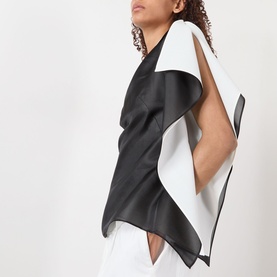 Model wearing Rohe black and white silk top with draped, structured panels and open back detail, styled with white trousers