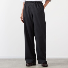 Model wearing Rohe Wide Leg Trousers in Anthracite Melange, elasticated waist, wide-cut legs, styled with a white top and brown loafers