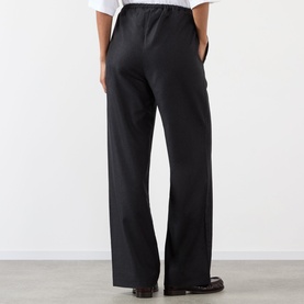 Model wearing Rohe Wide Leg Trousers in Anthracite Melange, elasticated waistband, wide-cut legs, back view, styled with white shirt