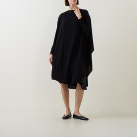 Model wearing Sarah Pacini Knitted Oversized Tunic Dress in black, midi length with asymmetric hem and boat neck, styled with black ballet flats