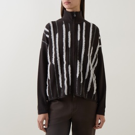 Model wearing Sarah Pacini brown zip-up jacket with white textured stripe knit detailing and funnel neck, styled with brown trousers.