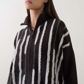 Model wearing Sarah Pacini brown zip-up jacket with white textured stripe detail and funnel neck collar, close-up view