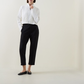 Model wearing Sarah Pacini Honeycomb Knit Zip Cardigan in white, styled with black tapered trousers and black ballet flats.
