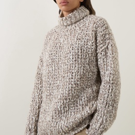 Model wearing Sarah Pacini beige chunky knit turtleneck sweater with textured marled yarn and relaxed oversized fit