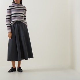 Model wearing Sarah Pacini striped mohair jumper in lilac and black, styled with dark midi skirt and black loafers.