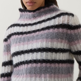 Model wearing Sarah Pacini mohair knitwear in pink, white and black stripes, with ribbed texture and high funnel neck.