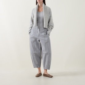 Model wearing Sarah Pacini cream knit cardigan, styled with grey stripe trousers and grey tank top, taupe flat shoes.