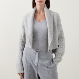 Model wearing Sarah Pacini cream knit cardigan with cable-knit sleeves and shawl collar, styled with grey vest and trousers