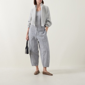 Model wearing Sarah Pacini cream knit cardigan with grey trousers, tan loafers, and black tote bag.