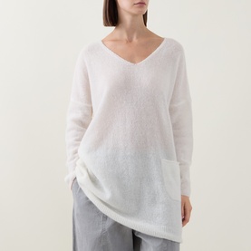 Model wearing Sarah Pacini cream knit jumper with V-neck and asymmetric hem, styled with grey wide-leg trousers