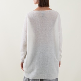 Model wearing Sarah Pacini cream knit jumper, back view, with relaxed oversized fit, paired with grey trousers.