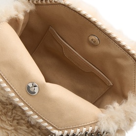 Stella McCartney cream crossbody bag interior showing tan suede lining, inner pocket with gold press-stud, and shearling exterior detail with silver