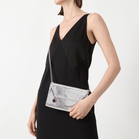 Model carrying Stella McCartney Falabella Chain Wallet in silver with chain strap and silver-tone hardware, worn crossbody over black dress