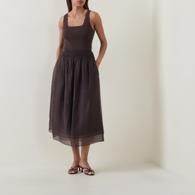 Model wearing Vince brown dress with square neckline, sleeveless bodice and gathered midi skirt, styled with brown strappy sandals.
