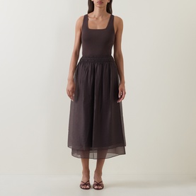 Model wearing Vince brown midi dress with square neckline, fitted bodice and gathered sheer skirt, styled with tan heeled sandals