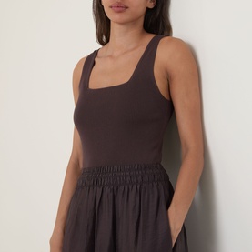Model wearing Vince brown dress with square neckline, ribbed bodice and smocked waist, styled in tencel lyocell blend fabric.