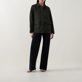 Model wearing Vince olive suede jacket with chest pockets, styled with navy wide-leg trousers and heeled sandals