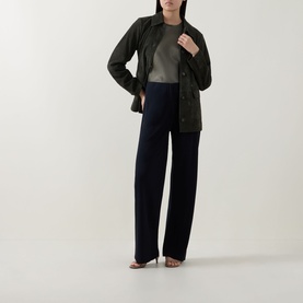 Model wearing Vince olive calf suede jacket, styled with grey top and navy wide-leg trousers