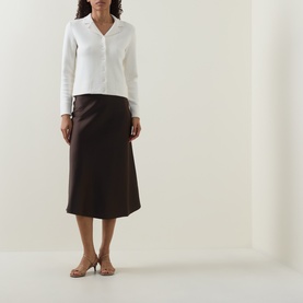 Model wearing Vince off white wool cashmere knit cardigan, styled with dark brown midi skirt and nude heeled mules.