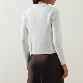 Model wearing Vince off white wool-cashmere knit top, back view, styled with dark brown wide-leg trousers.