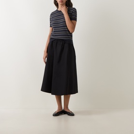 Model wearing Vince black cotton midi skirt with elasticated waist, styled with a striped tee and black ballet flats
