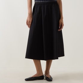 Model wearing Vince black midi skirt with elasticated waist, styled with black ballet flats
