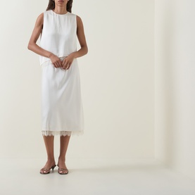 Model wearing Vince cream midi skirt with lace hem trim, styled with a matching sleeveless top and silver heeled sandals.