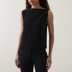 Model wearing Vince Draped Tank Top in black with asymmetric draped neckline, sleeveless, styled with black tailored trousers.